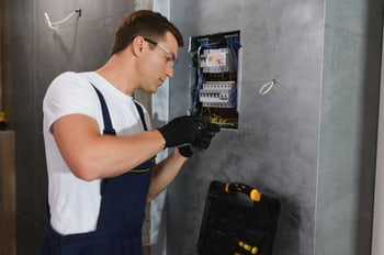 Bild Installateur der Sicherungskasten anbringt